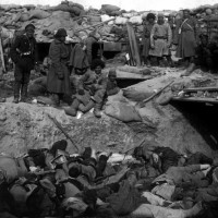Russian_soldiers_stand_over_trench_of_dead_Japanese