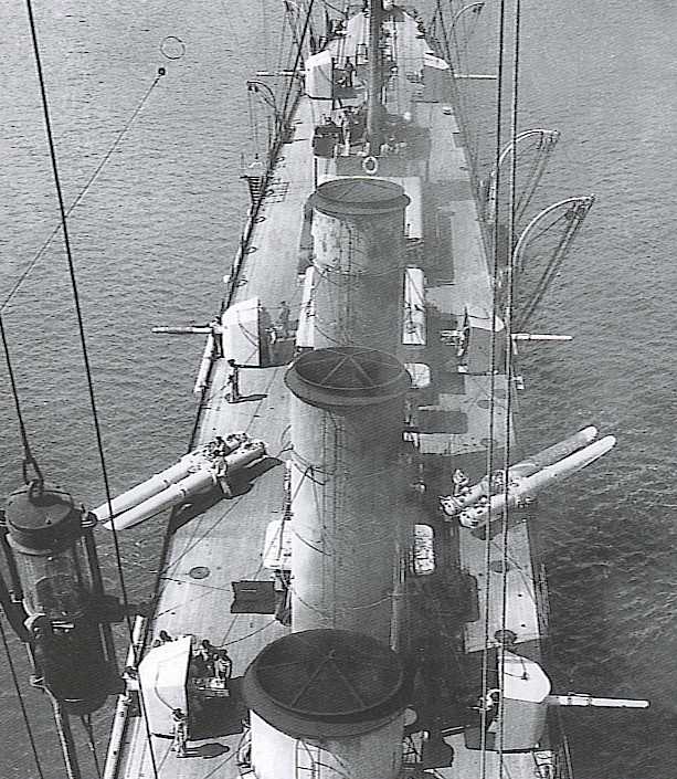 Na fotografii: Spojrzenie z bocianiego gniazda w kierunku rufy na smukłe śródokręcie szybkiego krążownika rozpoznawczego SMS "Saida" (typ "Novara") ["Admiral Spaun" - ulepszony.]. Bardzo dobrze widoczne obrócone na burty oba dwururowe aparaty torpedowe oraz armaty artylerii głównej. Lampy na pierwszym planie należą do zestawu składającego się z 5 wiszących elementów, które tworzyły tzw. "System Sygnalizacji Nocnej Sellnera.? Był on na wyposażeniu wszystkich większych jednostek cesarsko-królewskiej floty (wielobarwne lampy do sygnalizacji optycznej w nocy.). Krążowniki uzbrojono w dziewięć armat kal. 100 mm. W odróżnieniu od Admiral Spauna (armaty wz. K 10) były to zmodyfikowane armaty kal 100 mm L/50 K 11, skonstruowane w 1911 r. przez zakłady Škoda w Pilźnie, z żeliwnym płaszczem lufy. Obsługiwane ręcznie działa wg. systemu Škody i mające zamek klinowy odpalane były natomiast elektrycznie. Kierowanie ogniem również było bardzo precyzyjne, a to dzięki elektrycznemu przekazywaniu danych odnośnie odległości, bębnowi dokładnego odczytu kątów pionowych (austr. "Distanztrommel") i automatycznemu przesuwowi celownika lunetowego przy określeniu kąta wyprzedzania. Te same armaty weszły na wyposażenie późniejszych kontrtorpedowców typu Tátra oraz ich następców typu Ersatz Triglav. Masa działa wraz z zamkiem wynosiła 2020 kg, z dodatkową maską ochronną 7240 kg i mogła się ona przemieszczać w płaszczyźnie pionowej od -4° do 18°. Prędkość początkowa pocisku to 880 m/sek, a energia wylotowa pocisku to 542,7 mt, ciśnienie użytkowe 2800 atm. Zcalony pocisk miał masę 26,2 kg, z czego 6,6 kg przypadało na ładunek miotający i 13,75 kg na pocisk. Zasięg armat przy kącie podniesienia 14° wynosił 11 000 metrów. Maska przeciwodłamkowa o kształcie kołpaka miała z przodu pancerz o grubości 40 mm, a na bokach chroniło ją tylko 8 mm. Taką samą grubością charakteryzował się również dach. Uzbrojenie torpedowe było stosunkowo silne: na bokach pokładu i na rufie zamierzano ustawić w sumie trzy dwururowe wyrzutnie torpedowe kal. 533 mm, lecz ostatecznie ich uzbrojenie w tę groźną broń ograniczyło się do jednej dwururowej wyrzutni kal. 533 mm na rufie (po jednej na bak i sterburcie) oraz dwóch dwururowych aparatów kal. 450 mm, które zastąpiono dopiero kal. 533 mm pod koniec września 1915 r. Torpedy kalibru 533 mm typu "53 cm L/7,18? miały długość 7,18 m, ich masa wynosiła 1590 kg, a ładunek wybuchowy w głowicy wynosił 180 kg. Z prędkością 36 w pokonywały one dystans 6000 m, a przy prędkości 29 w 10 000 m. W razie potrzeby istniała możliwość ustawienia torów minowych, które mieściły 60 min morskich. Źródło: navweaps.com