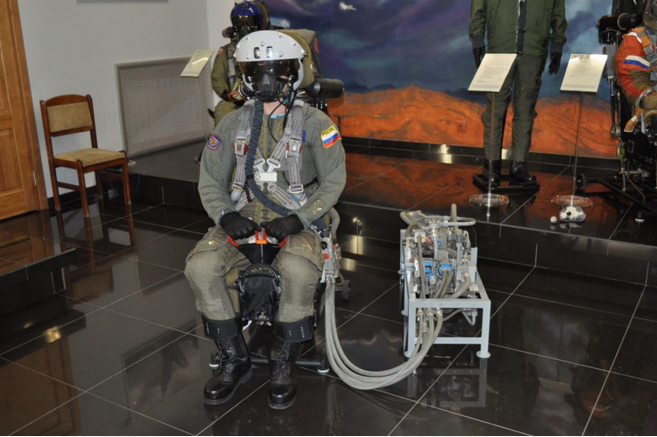 Pilot ubrany w skafander PPK-7, hełm ZSz-10 wraz z maską KM-36M na fotelu K-36D-5 oraz obok niego system tlenowy KS-50 / Źródło: mycity-military.com